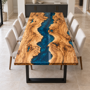 Elevated end view of an olive wood dining table with a blue epoxy resin river and cream upholstered chairs